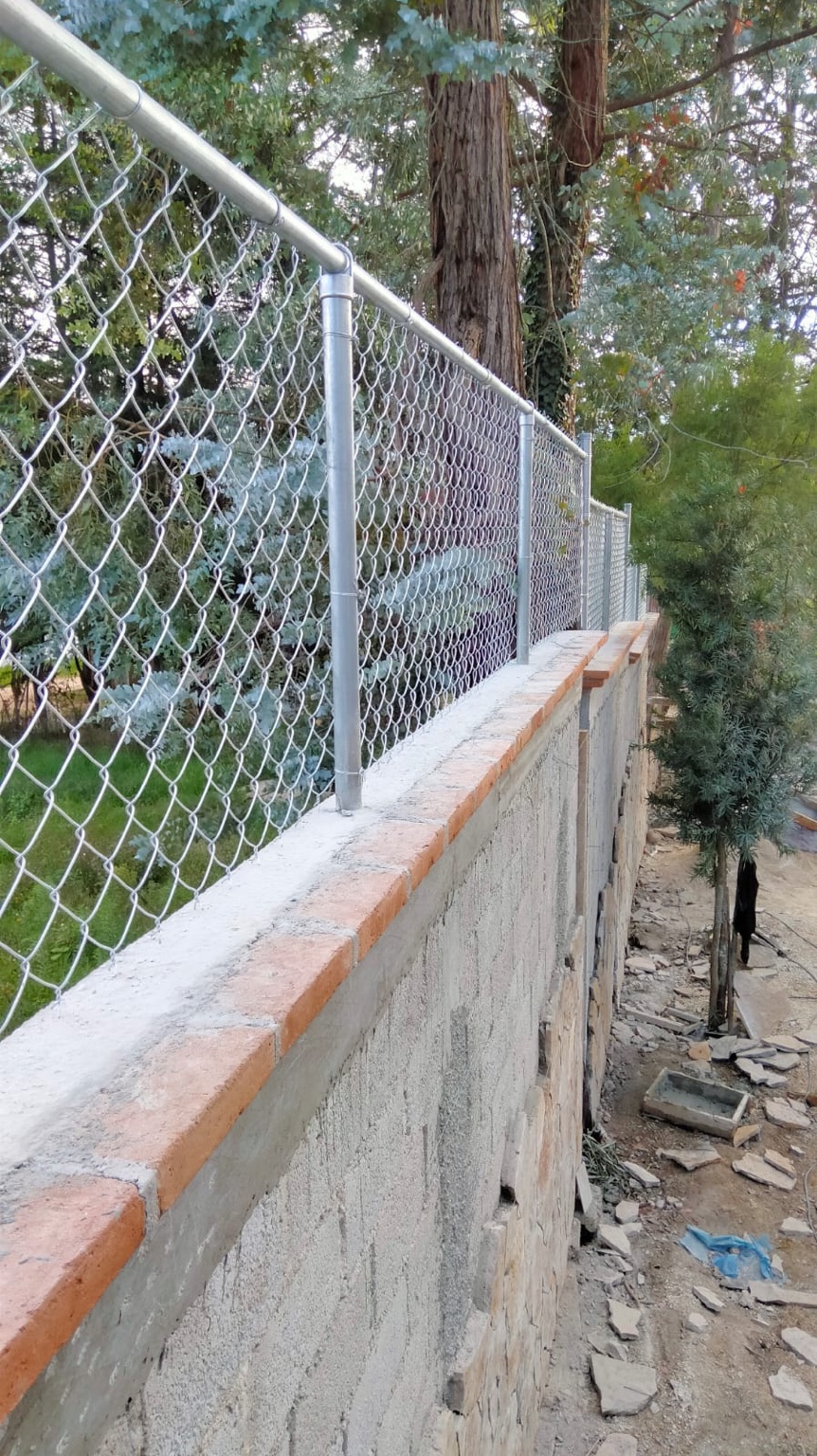 Enmallado de malla ciclón instalado sobre muro